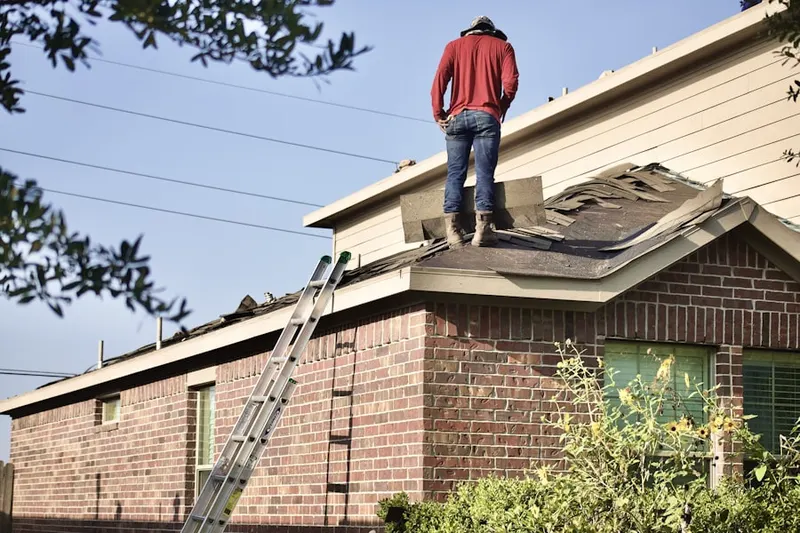 Professional roofer working on a residential roof in Heritage